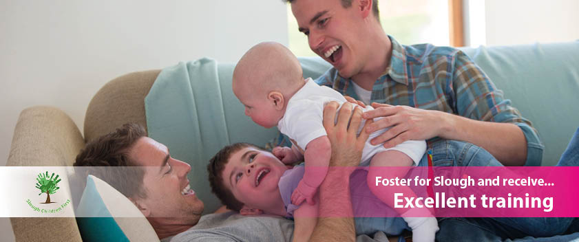 Two fathers with two young children on sofa. Text displays foster for Slough and receive excellent training