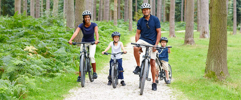 Family cycling through forest
